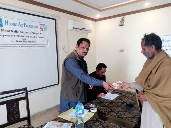 A recipient collecting their household's flood relief payment