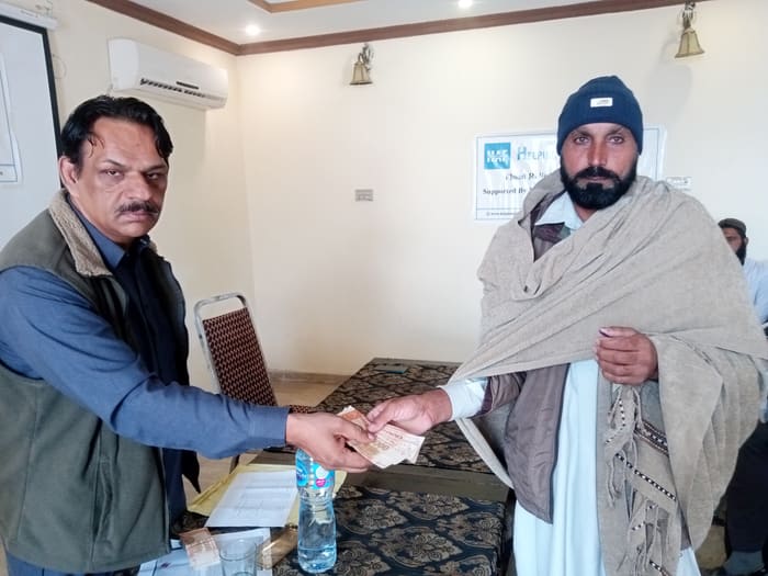 A recipient collecting their household's flood relief payment