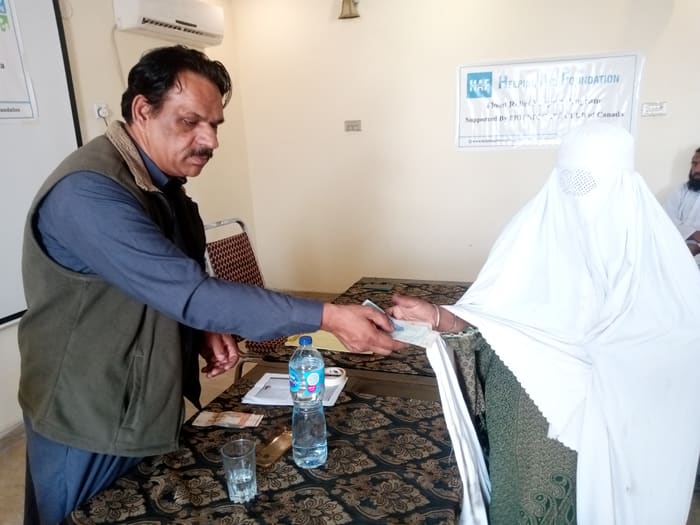 A recipient collecting their household's flood relief payment