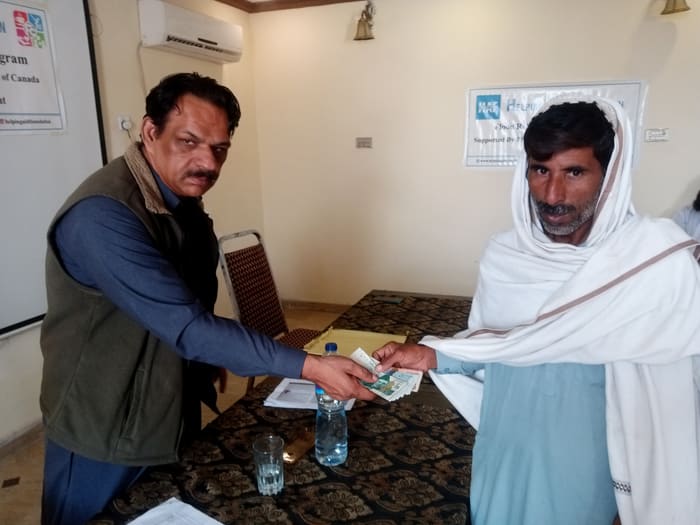 A recipient collecting their household's flood relief payment