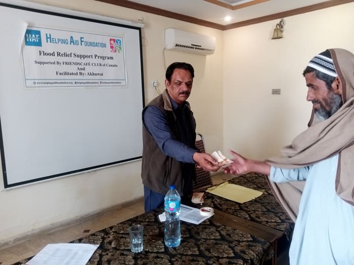 A recipient collecting their household's flood relief payment
