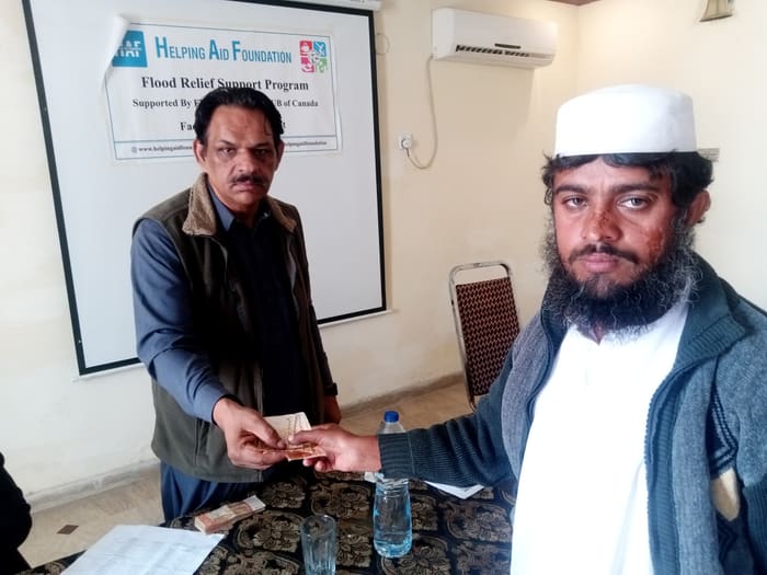 A recipient collecting their household's flood relief payment