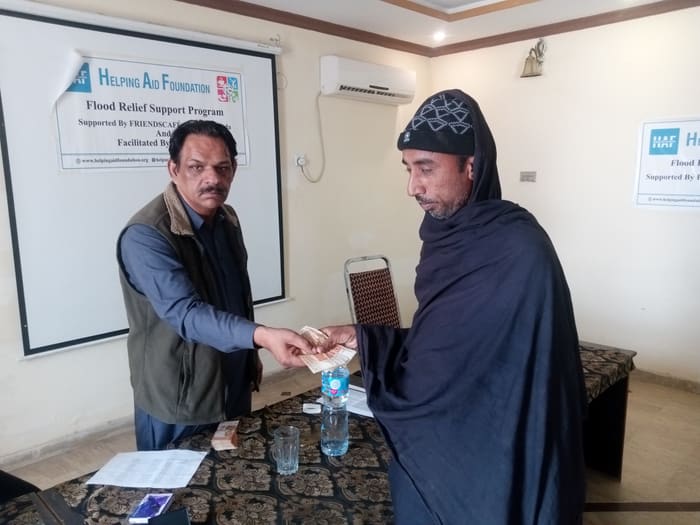A recipient collecting their household's flood relief payment
