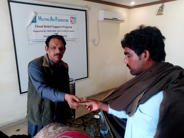 A recipient collecting their household's flood relief payment