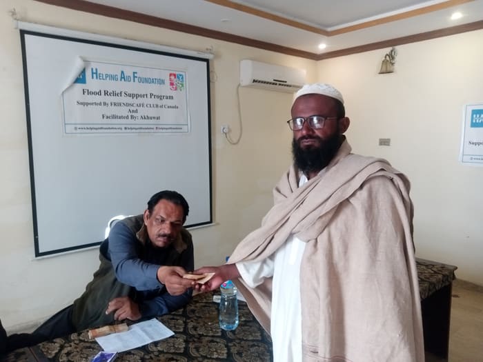A recipient collecting their household's flood relief payment