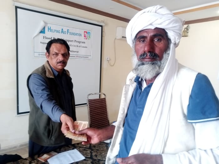 A recipient collecting their household's flood relief payment