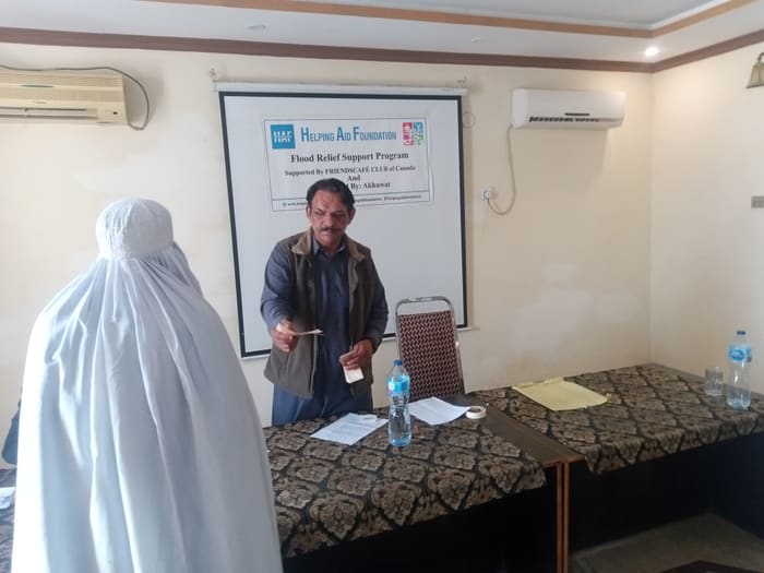 A recipient collecting their household's flood relief payment