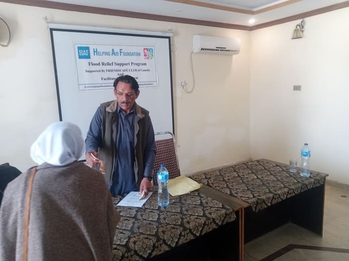 A recipient collecting their household's flood relief payment