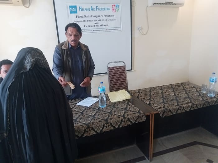 A recipient collecting their household's flood relief payment