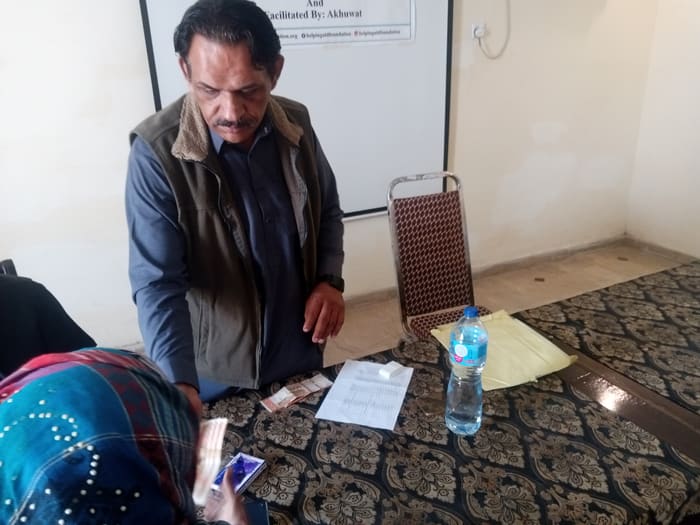 A recipient collecting their household's flood relief payment