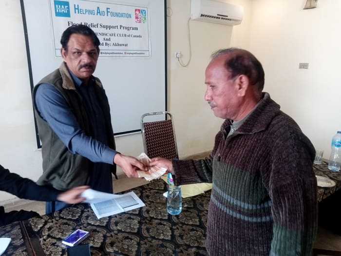 A recipient collecting their household's flood relief payment
