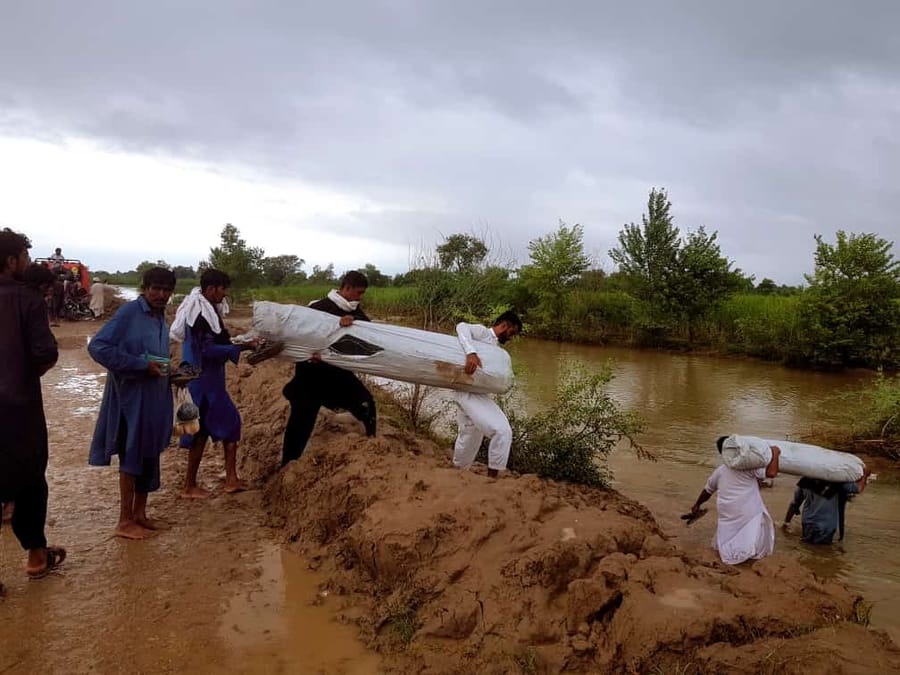 Residents working to clear a breached watercourse.