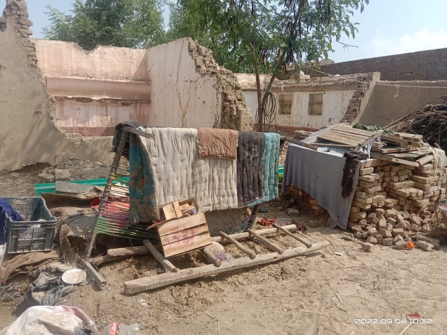 A damaged compound wall in a flood-affected village